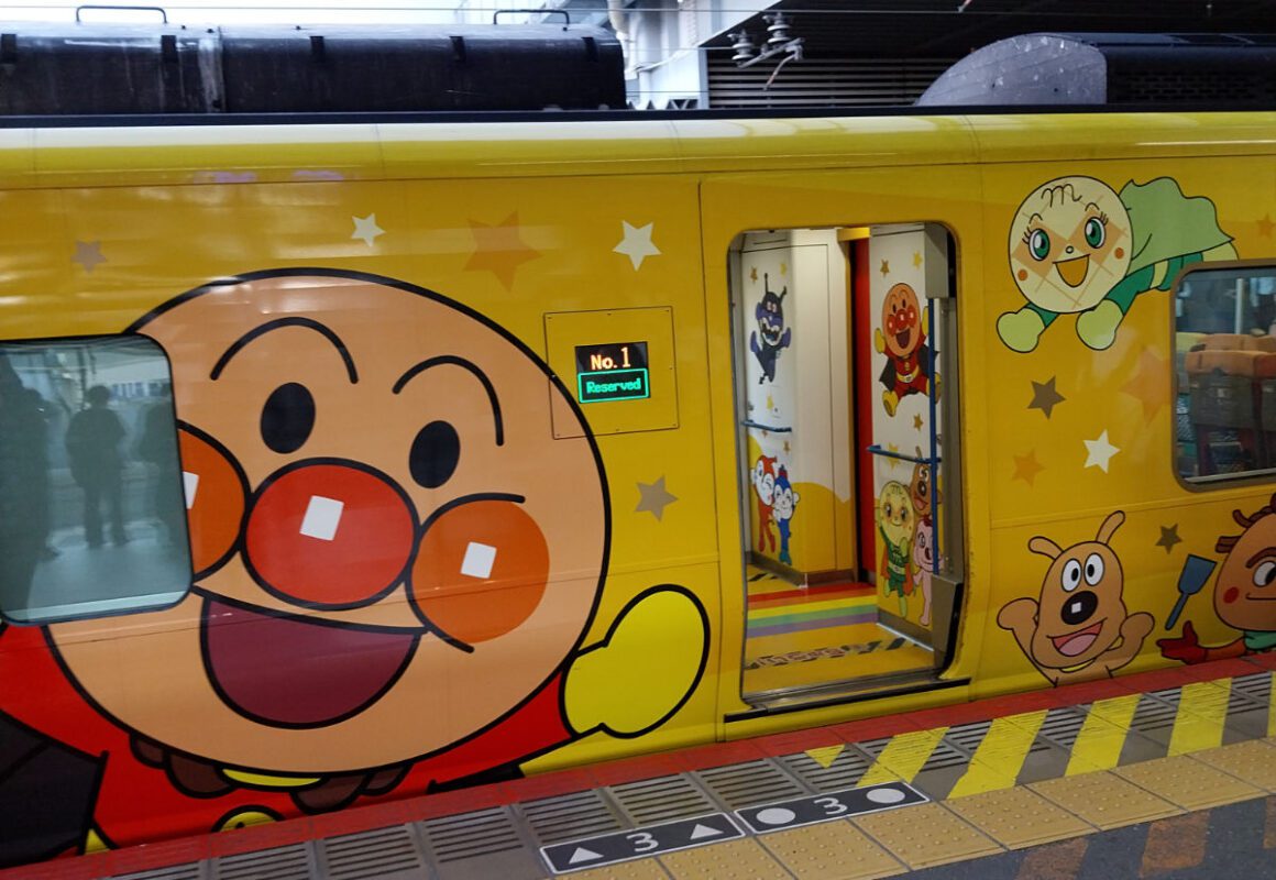 A colourfully decorated train on a station in Japan: Shikoku pilgrimage transportation
