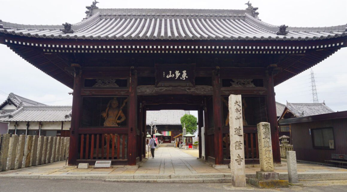 The entrance to Doryu-ji temple, with a wooden gatehouse and stone pillars