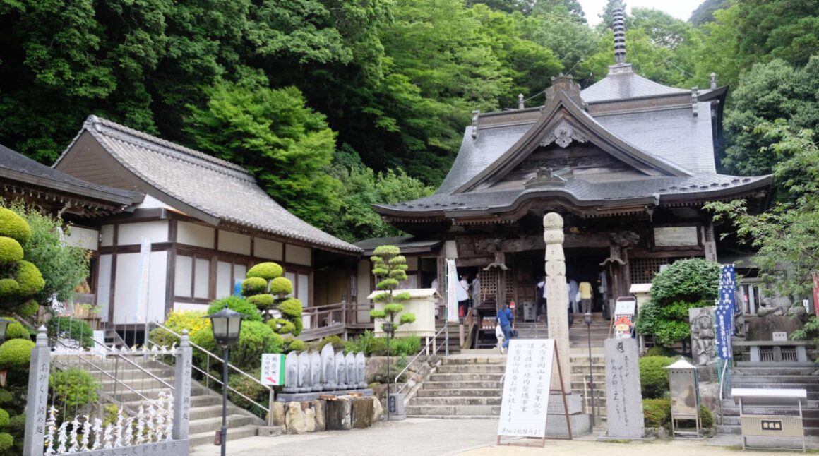 Several traditional Japanese buildings surround a small courtyard at Okubo temple